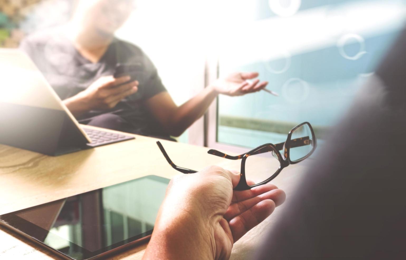 Mentor orientando estudante durante desenvolvimento de aplicativo mobile com código visível na tela